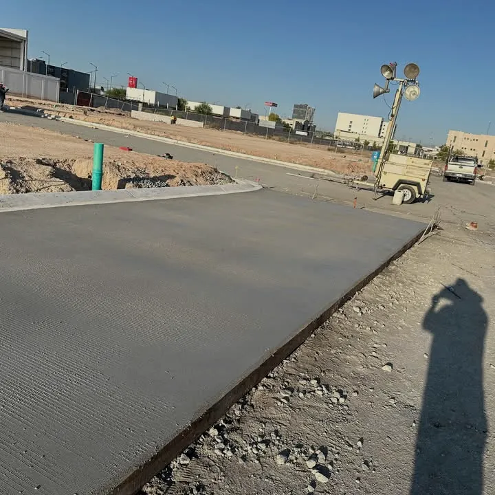 Firme de concreto terminado en sitio comercial con torre de iluminación